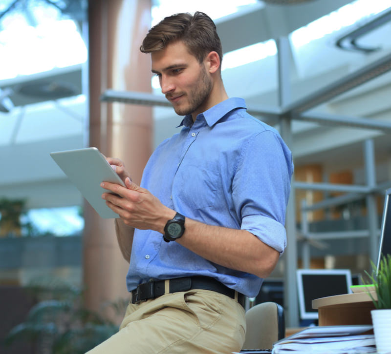 Man looks at a tablet in his office