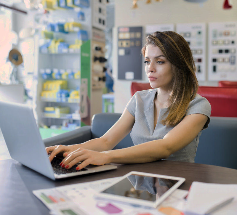 Female web designer working behind her laptop in the AllMediaLab web design studio.