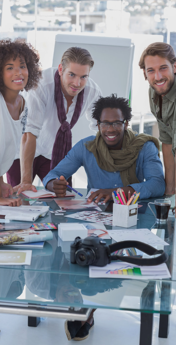 Meerdere designer in de AllMediaLab webdesign studio kijken lachend naar de fotograaf.