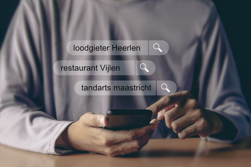 Man achter een mobile telefoon zoekend naar een bedrijf in Google Search